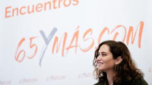Primer plano de la presidenta con el cartel del evento detrás donde se lee Encuentros 65 y más
