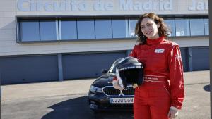 La presidenta ha visitado las instalaciones del Circuito de Madrid Jarama-RACE La presidenta con el casco en la mano y mono de piloto posando ante un coche