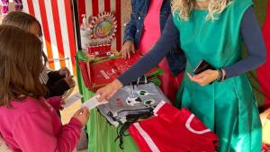 Persona repartiendo merchandising de comercios mágicos 2021