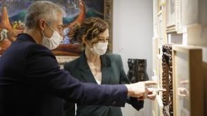 La presidenta observa una obra que le enseña uno de los comisarios