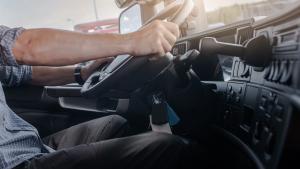 Las manos al volante de un conductor dentro de un camión