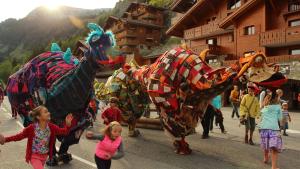 Unos niños corren entre personas disfrazadas de dinosaurios
