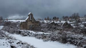 Una foto de Alfredo Caliz donde se ve una ruina en el campo cubierta de nieve