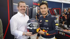 El consejero de Cultura, Turismo y Deporte de la Comunidad de Madrid, Mariano de Paco Serrano recibe un casco de manos de Checo Pérez
