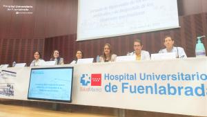 Personas sentadas en una mesa en un salón de actos