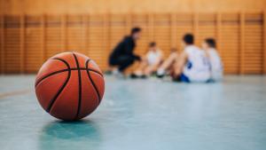Pelota de baloncesto en la cancha con equipo al fondo