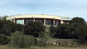 Fachada circular del edificio con cristalera y muro exterior con vegetación