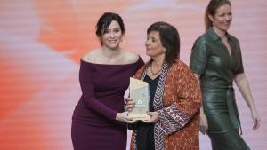 Isabel Diaz Ayuso entregando una placa conmemorativa a una mujer