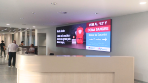 Pantalla grande en hall de hospital con una campaña