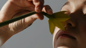 Imagen de una pernosa oliendo una flor