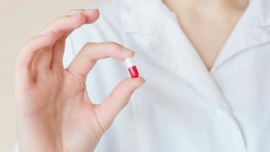 Imagen de una persona con un medicamento en la mano