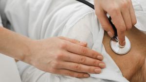 Un médico ausculta a un paciente