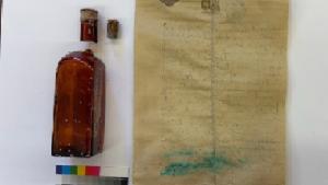 Botella y papel escrito localizada durante el seguimiento arqueológico