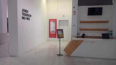 Mesa con libros y ascensor en una sala de exposiciones