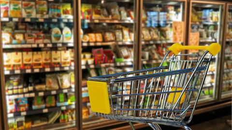 Carro de supermercado con lineal de neveras detrás
