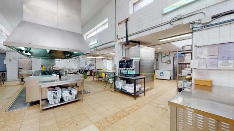 Cocina. Amplia cocina industrial de acero inoxidable. De techos muy altos, con una circulación muy amplia y azulejos blancos de suelo a techo.