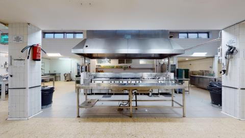 Cocina. Amplia cocina industrial de acero inoxidable. Bien iluminada y ventilada.