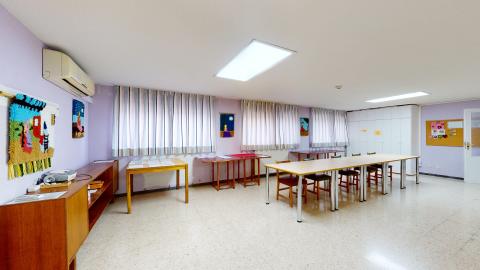 Terapia ocupacional. Amplio salón en color lavanda con mobiliario de madera y amplios ventanales. Hay mesas y sillas que se acomodan de acuerdo con las actividades a realizar.