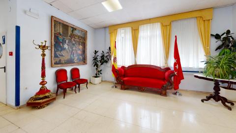 Estancia romántica. Es una esquina decorada al estilo romántico. A la izquierda cuelga una gran pintura, frente a ella dos sillas de madera tapizadas en rojo y un gran perchero de madera en rojo y dorado. Al frente una gran ventana con cortinas en amarillo y enfrente de ésta un gran sofá también de madera tapizado en rojo. A los lados del sofá se ubican la bandera de España y de la Comunidad de Madrid. Hasta la derecha, una mesa circular de madera de un solo pie con un gran helecho al centro.