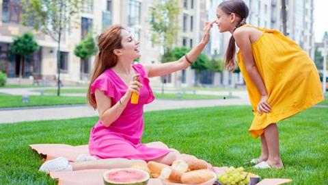 Día Europeo del Cáncer de piel mujer poniendo crema a una niña