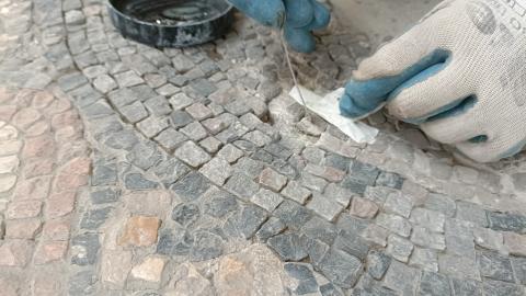 unas manos restaurando un mosaico