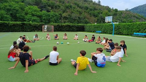 Jóvenes en circulo sentados en césped al aire libre