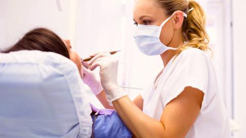 paciente atendida en consulta por ortodoncista mujer con mascarilla