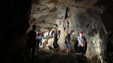 Jóvenes dentro de una cueva con cascos rojos