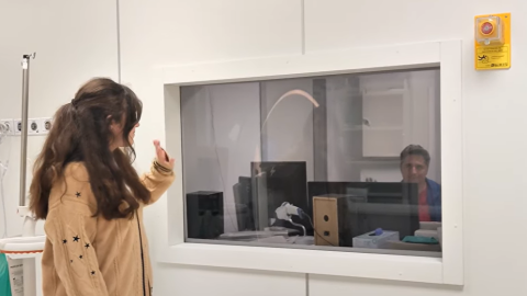 Una niña explica en qué consiste una resonancia magnética Una paciente saluda a profesional en la sala de resonancia
