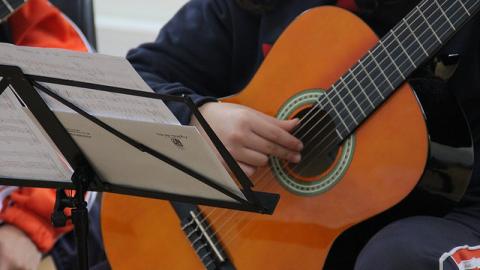 Guitarrista tocando frente a una partitura