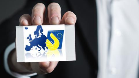 Mano ofreciendo una oportunidad de trabajo contenida en una tarjeta que muestra el Mapa de la Unión Europea