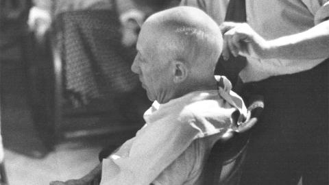Arias cortando el pelo a Picasso. © Fotografía David D. Duncan. VEGAP, Madrid 2026 Retrato de Picasso en una silla de barbero, de perfil
