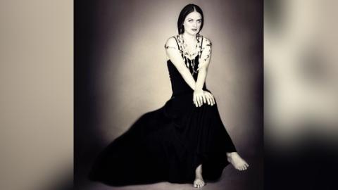 Mujer sentada con  un vestido negro
