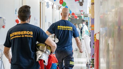 Los bomberos reparten regalos por las habitaciones del hospital