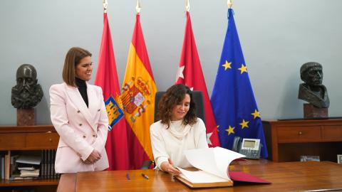 La presidenta firmando un libro, junto a la alcaldesa de Alcalá