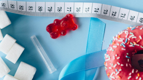 Imagen de un lazo azul, alimentos dulces y una cinta métrica