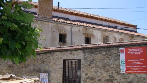 Imagen de un edificio con fachada de piedra y una puerta con reja