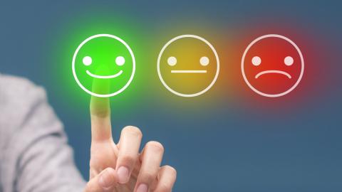 Dedo pulgar señalando un emoticono alegre