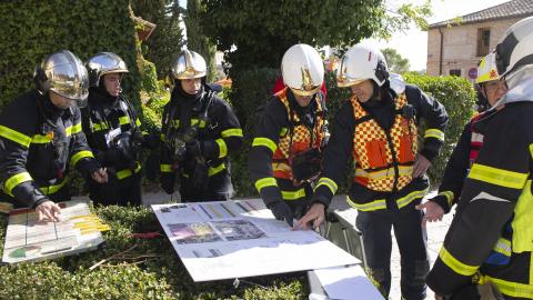 Simulacro de incendios de Boadilla del Monte. Fotografía La Famosa Productora grupo de bomberos mirando las fichas de salvaguarda