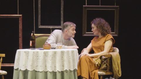 imagen de escena  muestra un hombre y mujer sentados ante una mesa 
