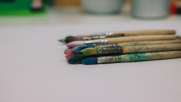 Pinceles manchados de pintura sobre una mesa en blanco