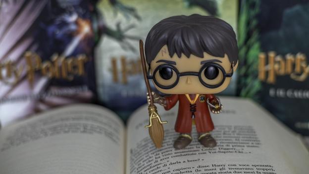 Muñeco Funko de Harry Potter con escoba sobre un libro