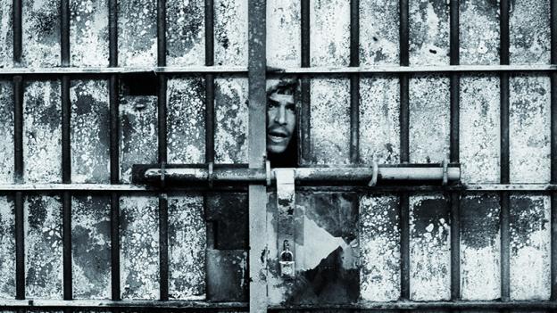 Rostro de un hombre asomando por el hueco de una puerta