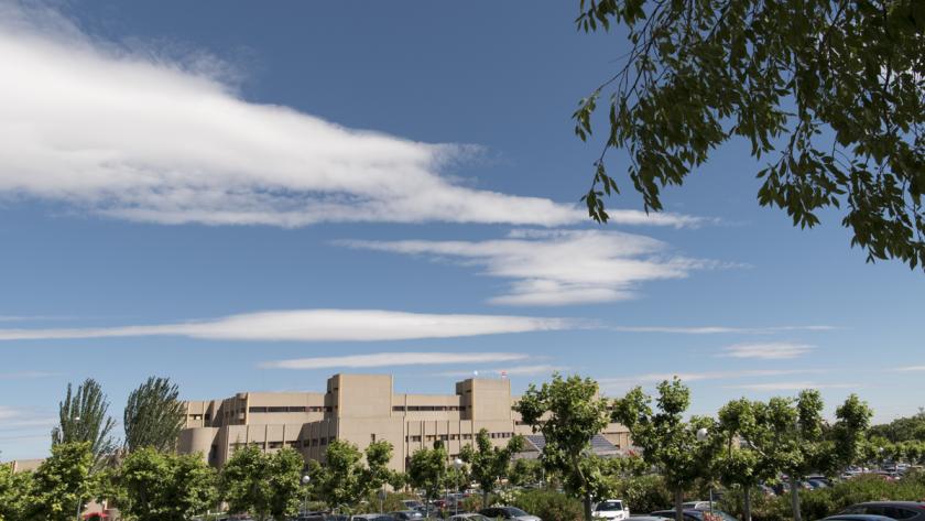 Vista con nubes y árboles de la fachada del Hospital público de Getafe