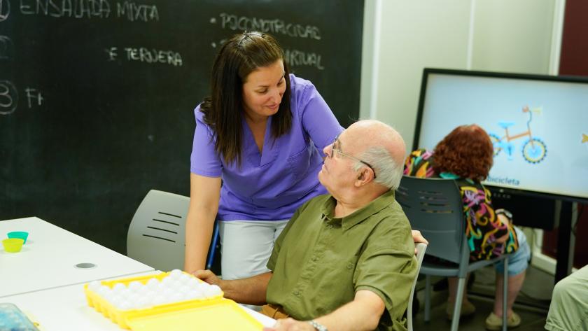 Señor junto a una auxiliar en centro de dependencia