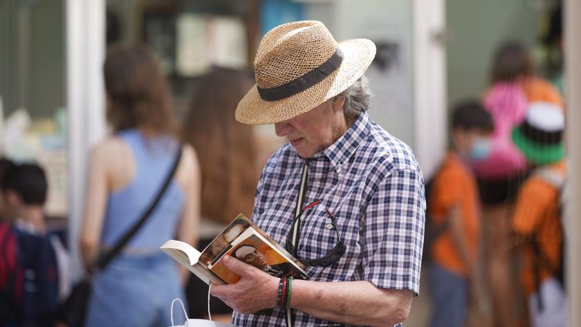 Visitante ojeando un libro en la Feria del Libro 
