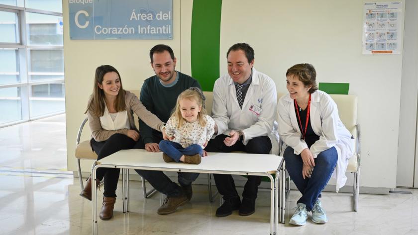 Irene, paciente del Gregorio Marañón junto a sus padres y médicos Profesionales, padres y paciente sentados para hacerse una foto