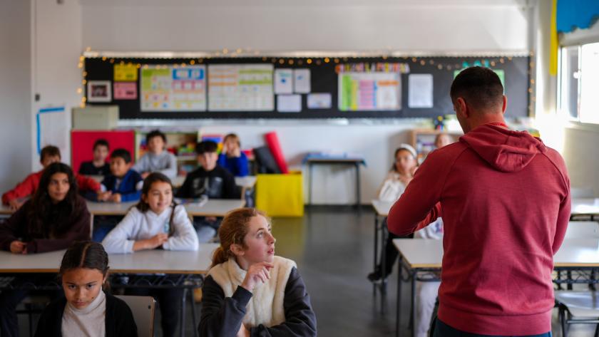 Niños atienden en clase mientras le dan una charla
