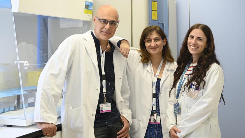 Tres investigadores frente a unas cabinas de un laboratorio