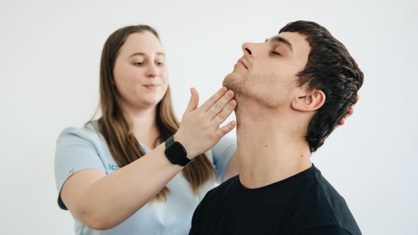 Profesional sanitaria ayudando a hacer ejercicios de cuello 